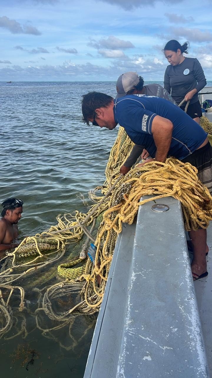 The Beyond The Reef team hauling ghost rope aboard the boat