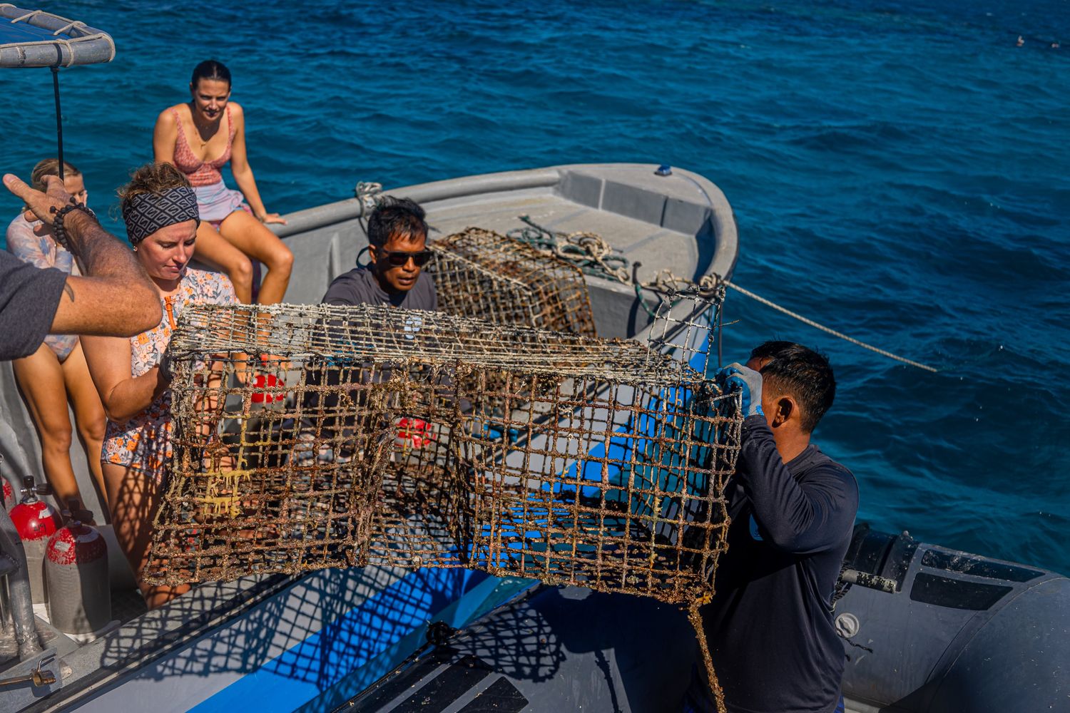 Lifting an abandoned fish trap onto the boat